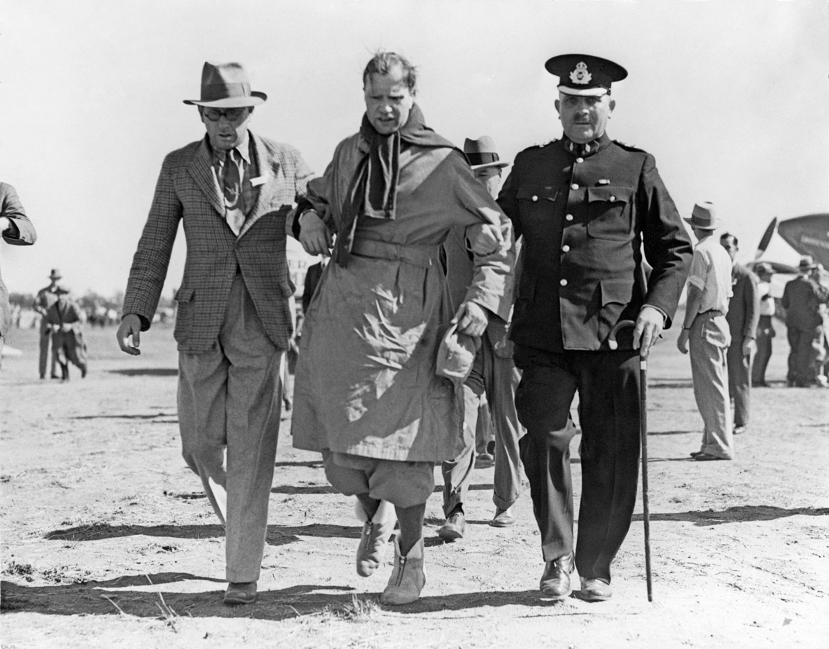  An exhausted Charles Scott being assisted after landing at Charleville, Queensland (State Library QLD) 